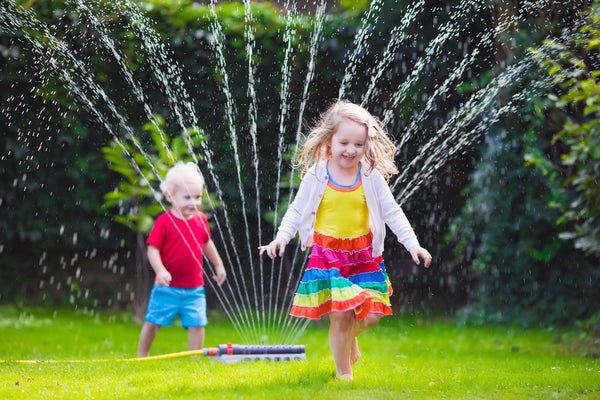 Kids running through sprinkler