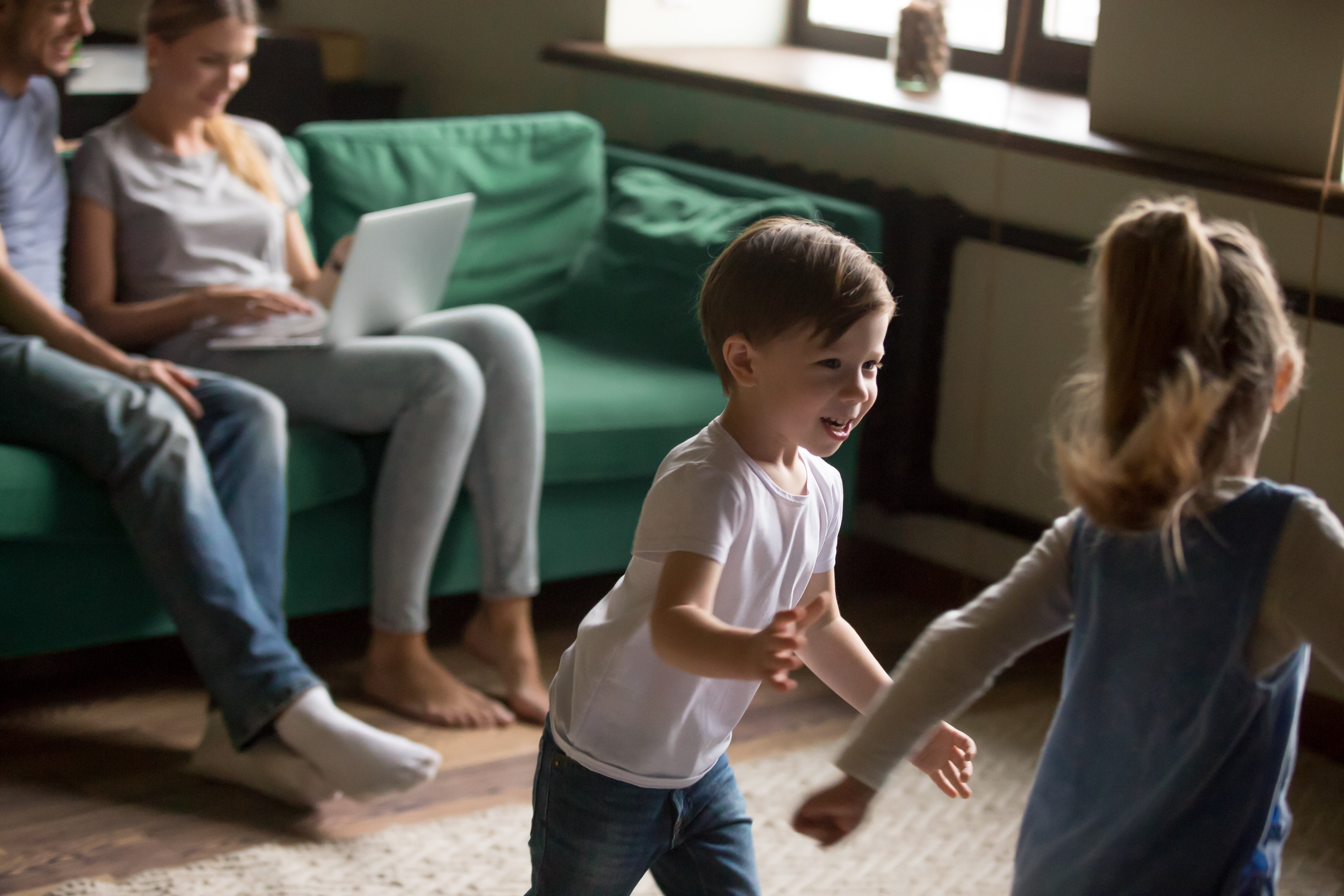 Kids playing with parents working