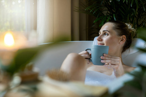 Woman lounging in bath with tea