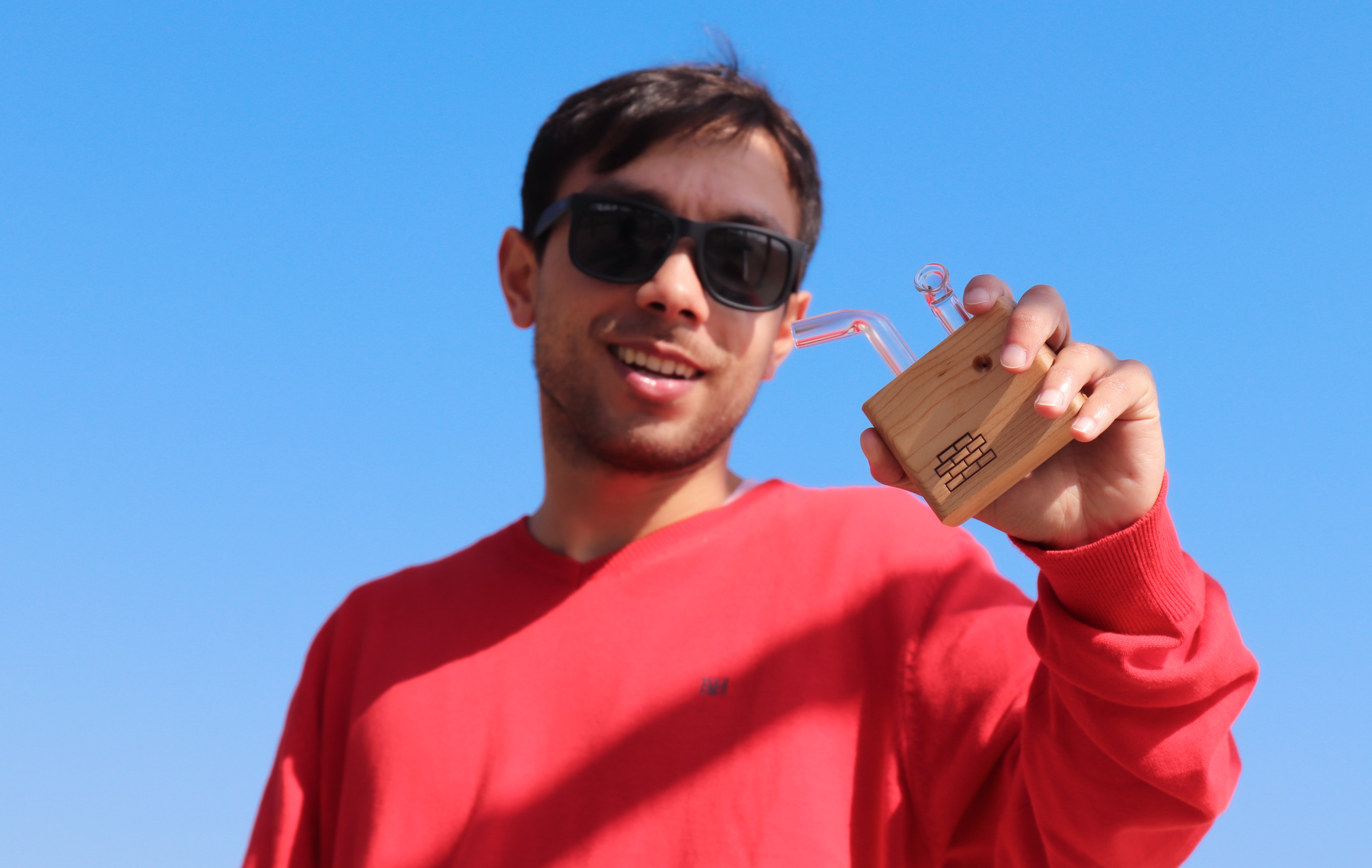 foto de noe con vaporizador de madera modelo Junior de Sticky Brick con cielo azul de fondo