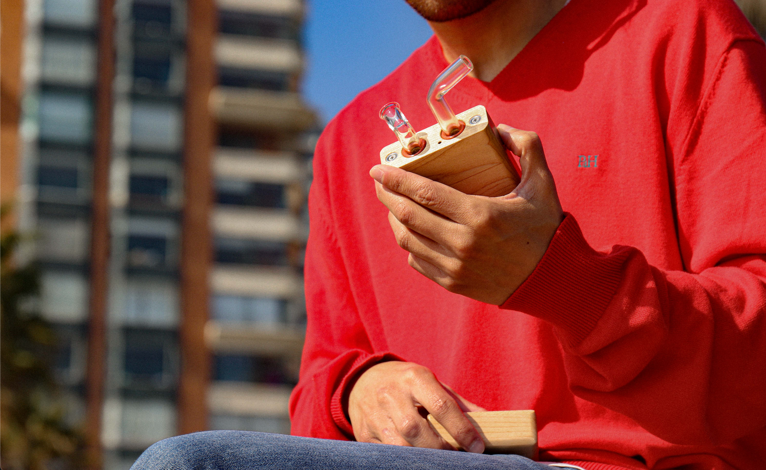 Noé con vestido con jersey rojo sosteniendo un vaporizador junior de sticky brick