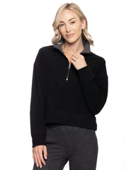 A woman in a black reversible quarter zip sweater