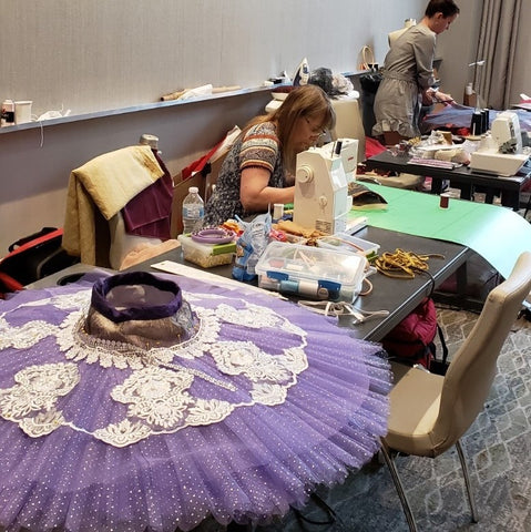 A work-in-progress Le Corsaire tutu by Alberta costumer Laura Light Piercey lies on the prep table, while Suzanne Speiss puts finishing touches on her Raymonda bodice. Photo by Amy Brandt.