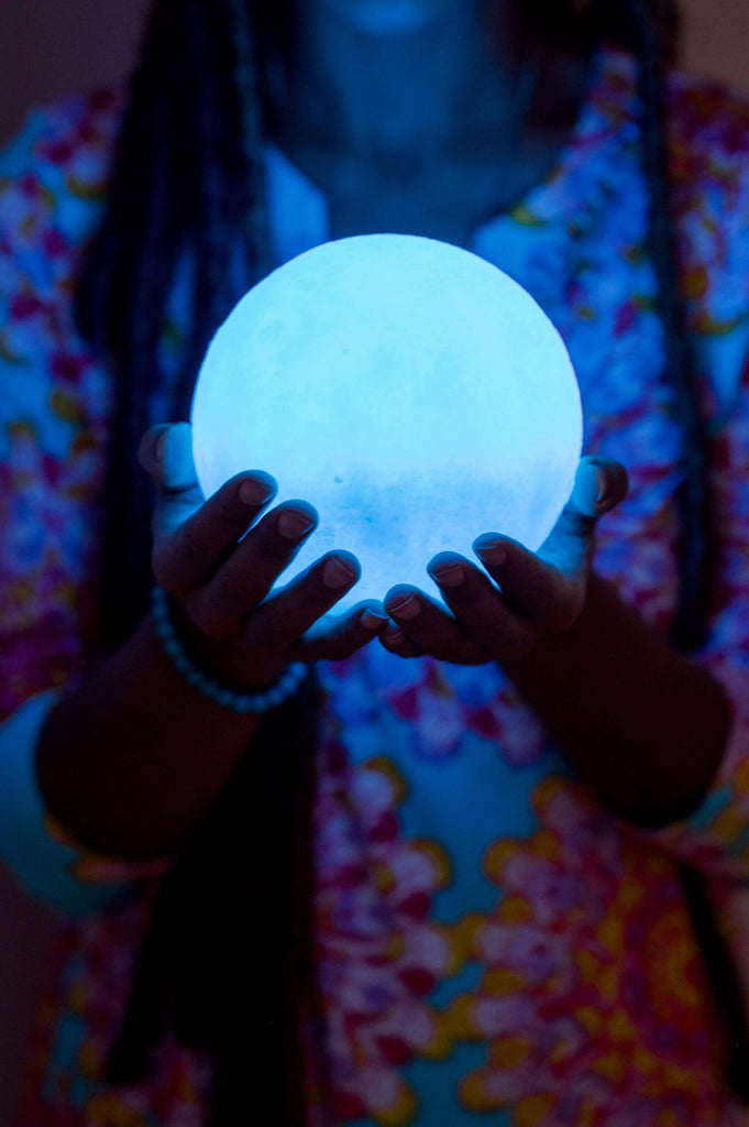 Should I charge crystals under the full moon? woman holding moon