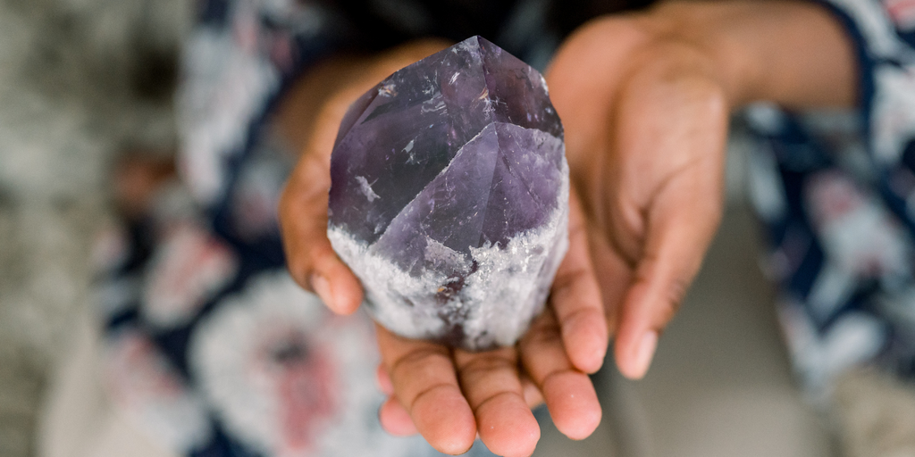 hands holding amethyst point