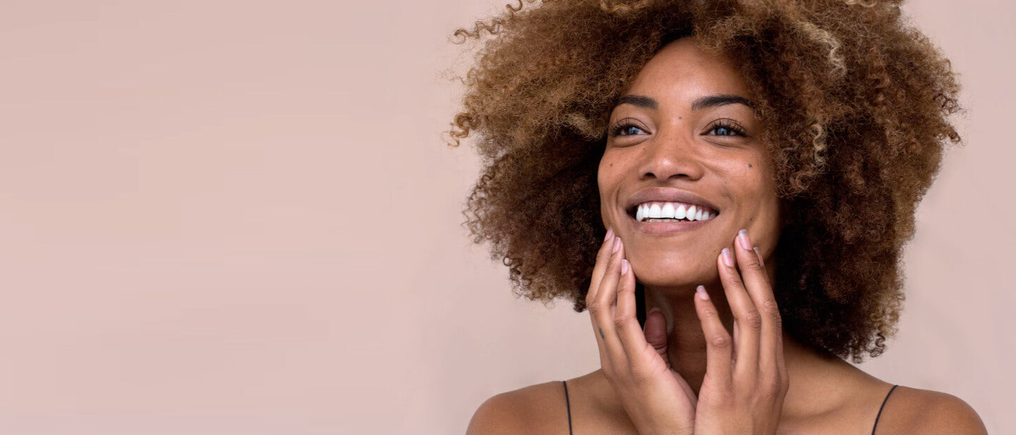 A smiling woman over a pink background