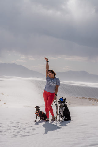 ashley and her two dogs together on a sand dune
