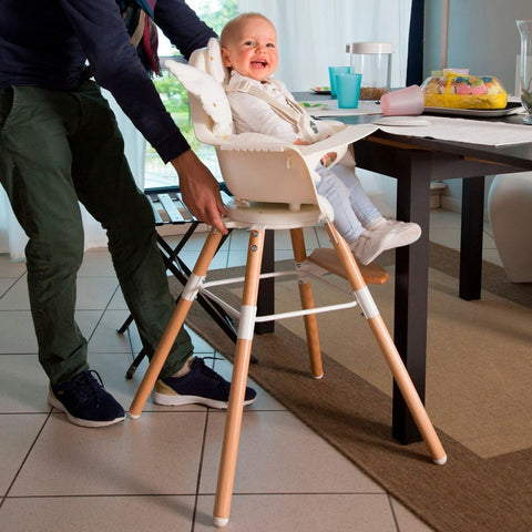 A baby sat in a highchair at the dining table