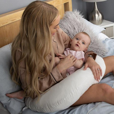 mum holding baby with nursing pillow