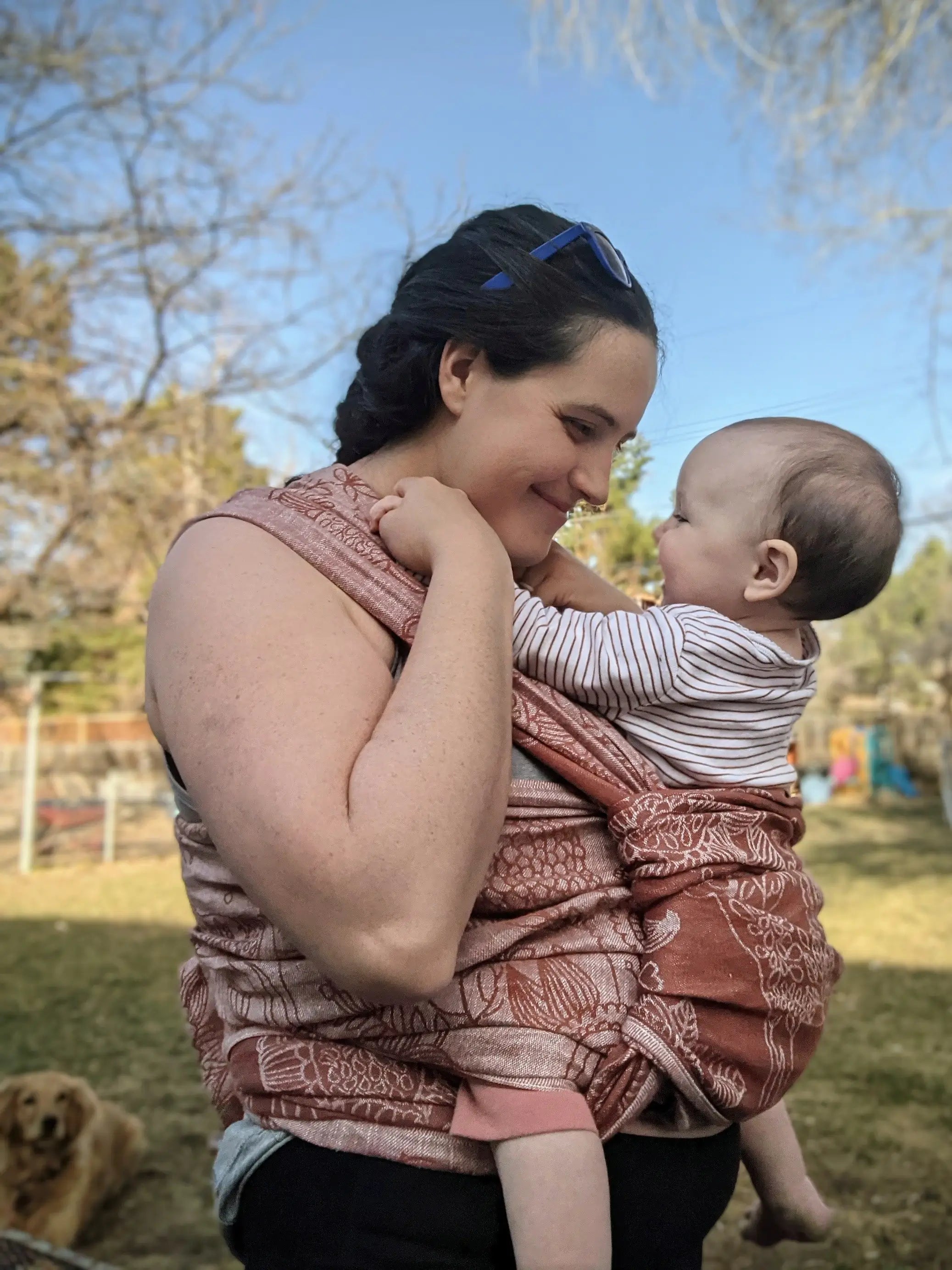 woman wearing a baby in a didymos woven wrap 