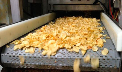 Máquina de fábrica produzindo as batatas chips