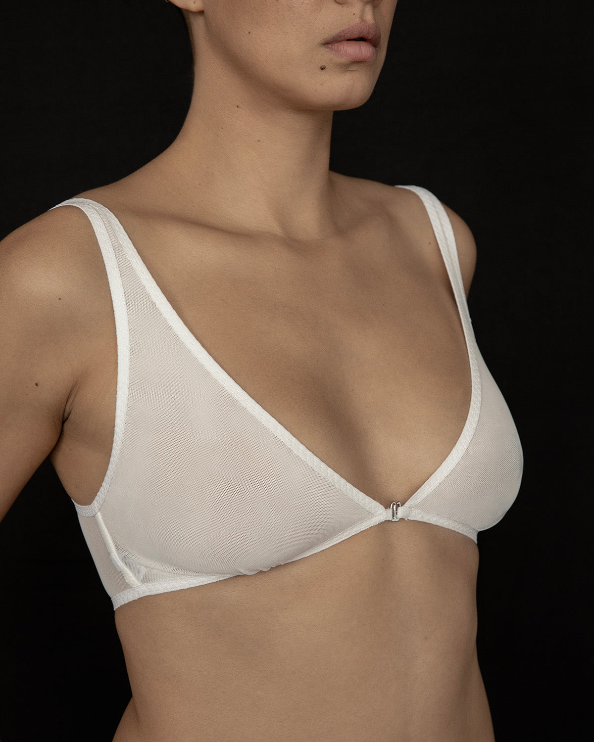 The Kye Intimates Dive Bra in the color bone. A deep V neck bra with front closure, and adjustable shoulder straps. This sheer bra provides gentle, wireless support. Offering the perfect balance between comfort and functionality.  