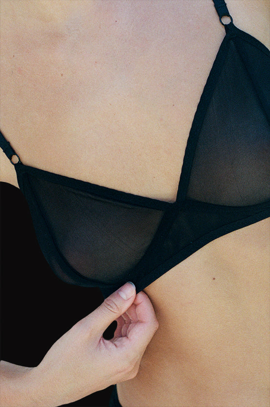 A zoomed in view of the Kye Intimates Form Bra in the color black. This bra offers the perfect balance between structure and comfort. This sheer bra is wire free, with adjustable shoulder straps and an adjustable back clasp. This wire free v neck bra provides moderate support, and is comfortable yet feminine.  Edit alt text