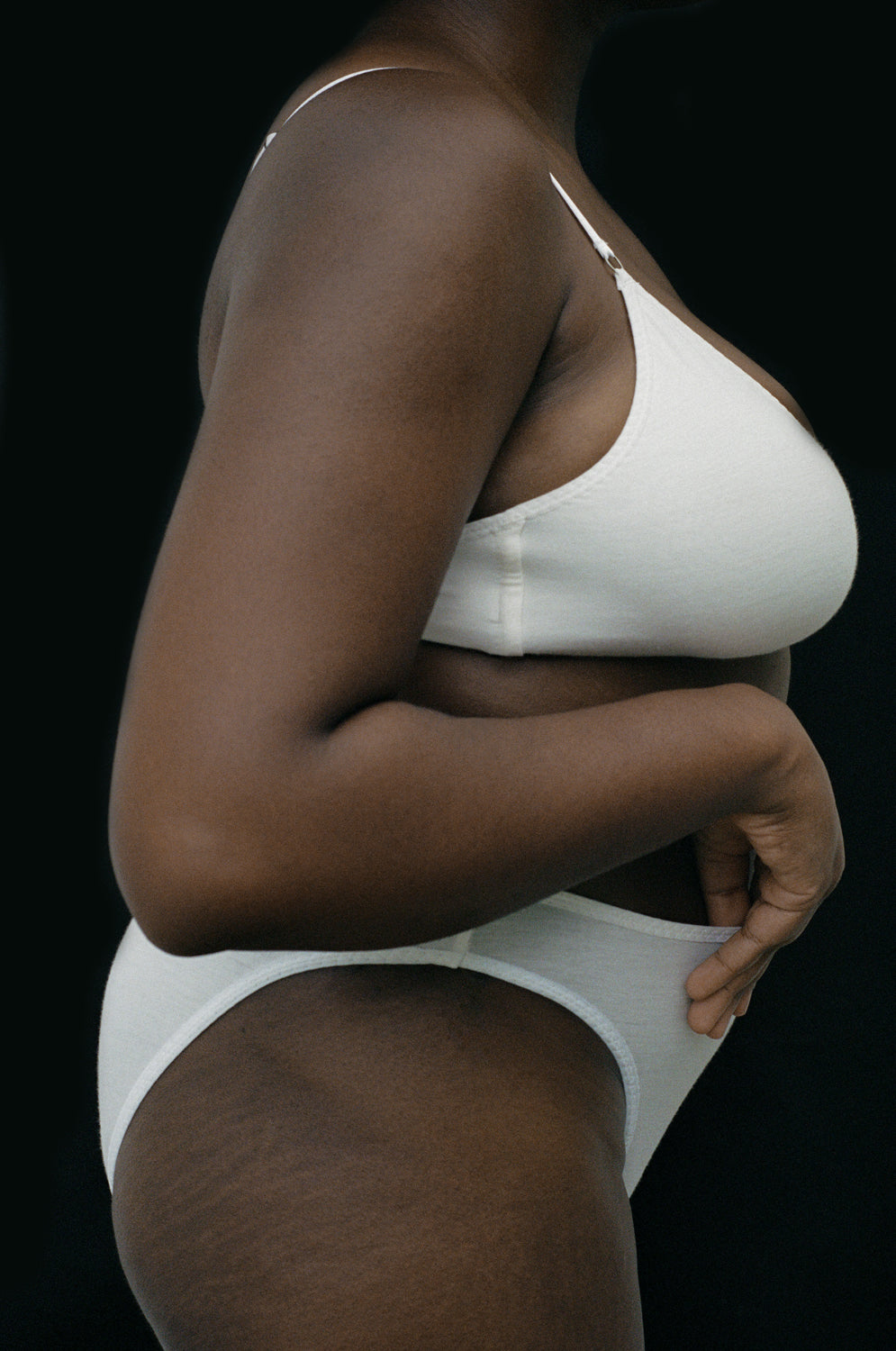 Side view of a model wearing Kye Recline Brief bamboo French cut briefs in white. The breathable bamboo fabric and modern design highlight the comfort and style provided by Kye Intimates.