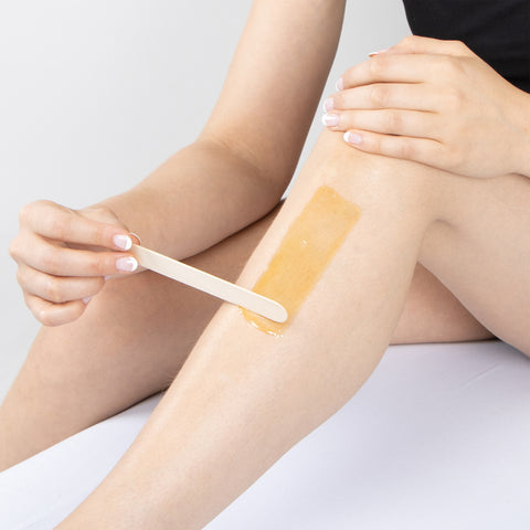 Woman waxing leg using Parissa Sugar Wax