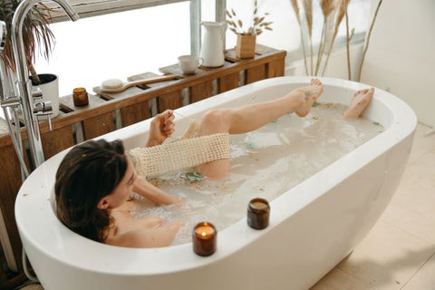 Woman exfoliating her skin in the bath