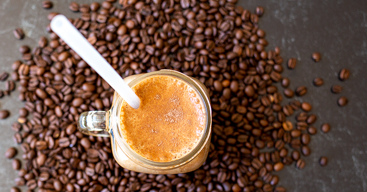 Coffee smoothie surrounded by coffee beans