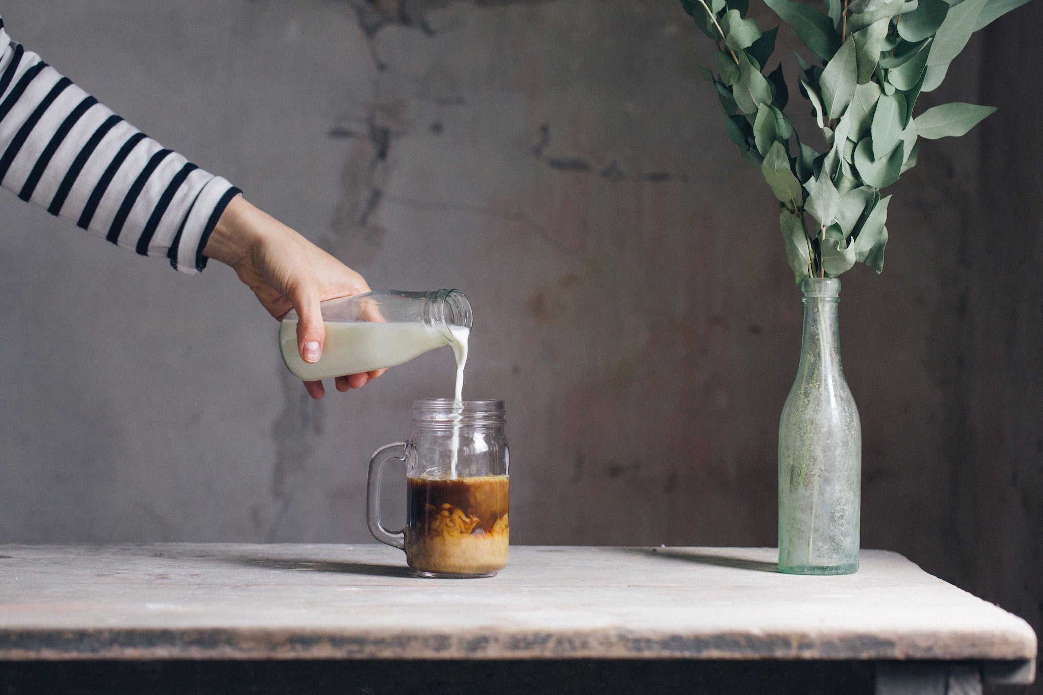 pouring creamer in coffee