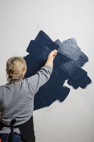 apply paint to the wall with large brush