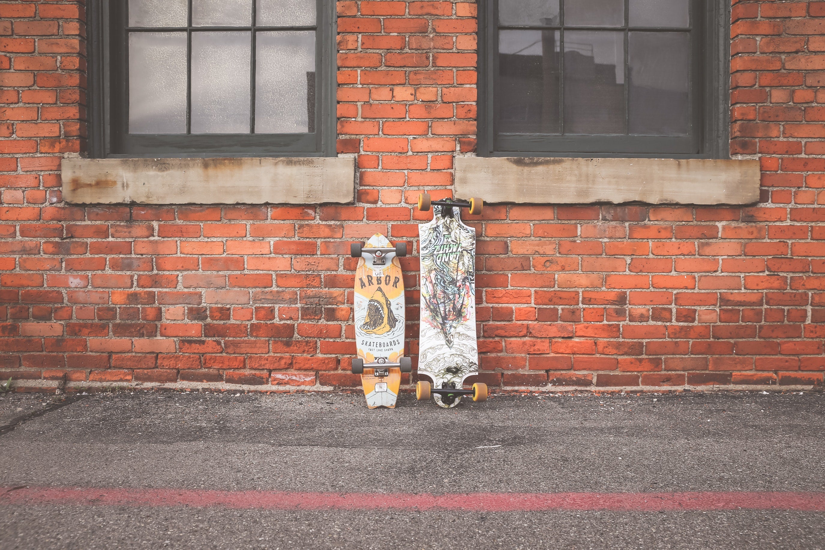 Two Skateboards On Brick Wall