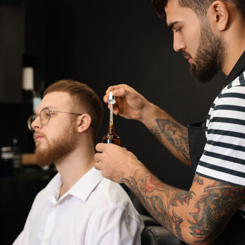 barber preparing beard oil for client