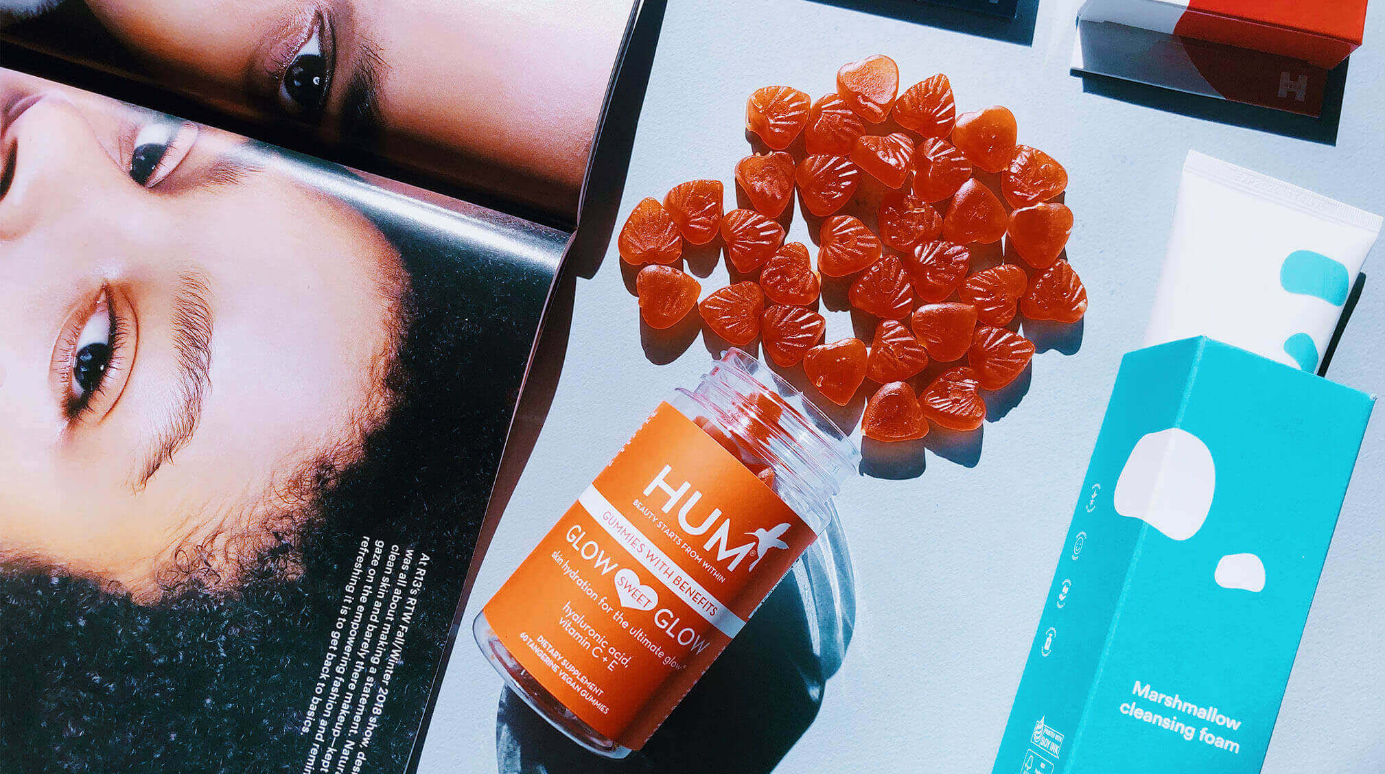 Hum Nutrition Glow Sweet Glow gummies spilling out of contain with Enature Marshmallow cleansing foam