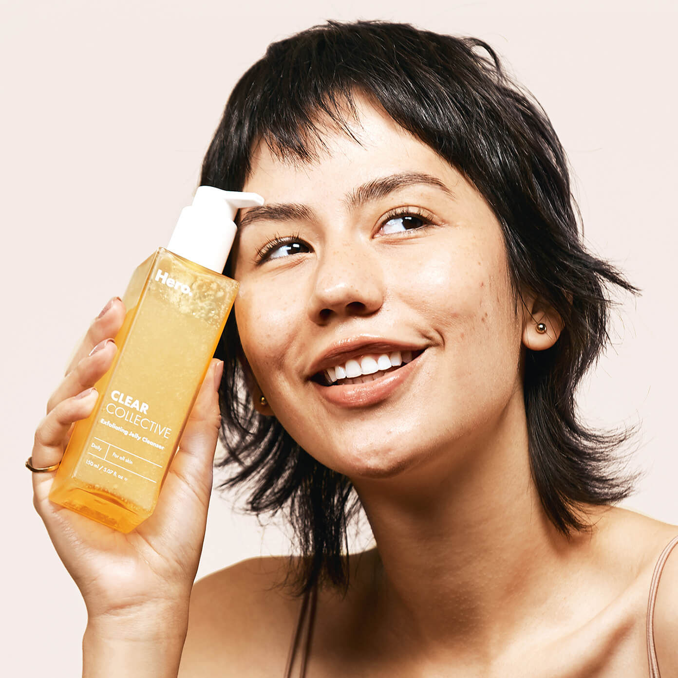 Model holding Clear Collective Exfoliating Jelly Cleanser 