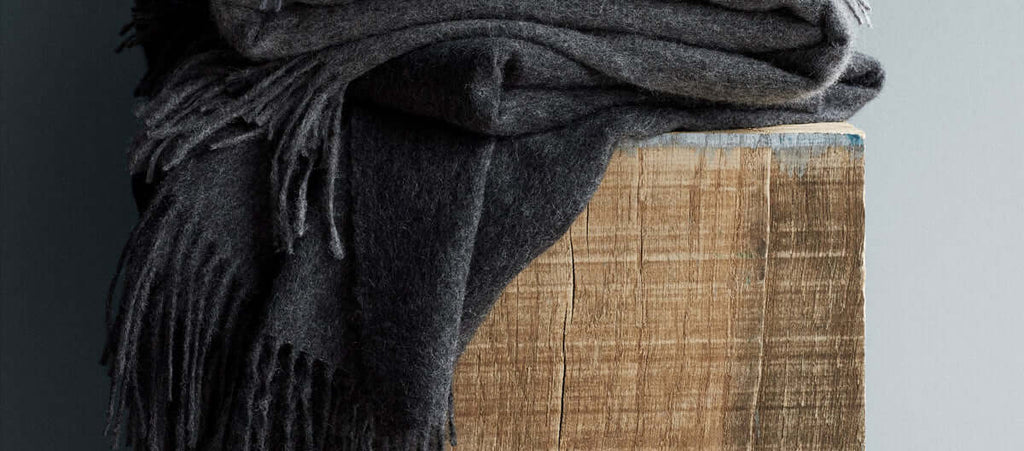 Alpaka Decke Classic in der Farbe grau auf Holzbalken dekoriert