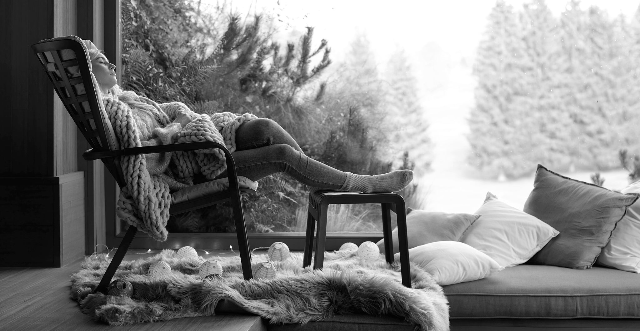 Folio relax armchair with girl at the window looking into the autumn garden, black and white photo