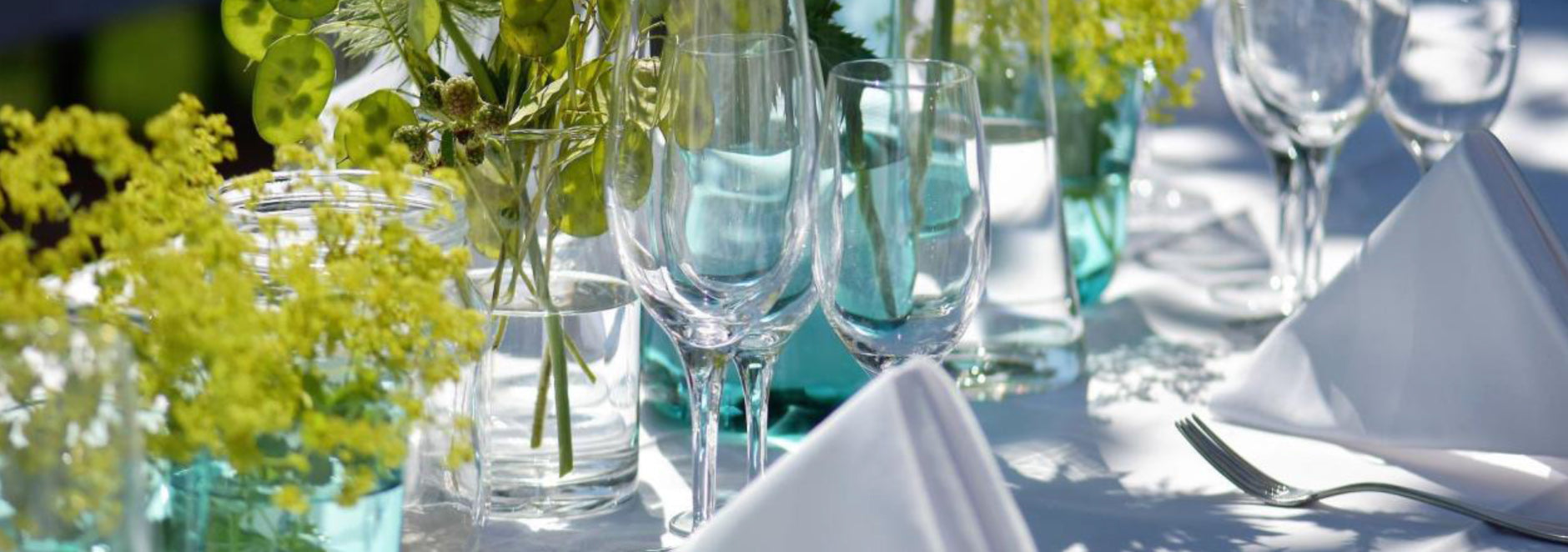 Stoffservietten für die Gastronomie auf festlichem Tisch mit Esstellern, Gläsern und Besteck sowie Dekoration in Szene gesetzt