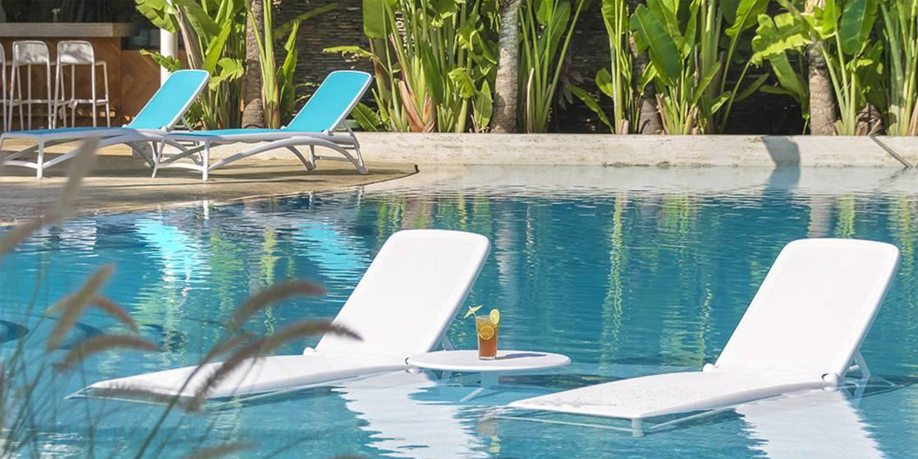 Quatre chaises longues Nardi Atlantico de couleur Bianco au bord de la piscine