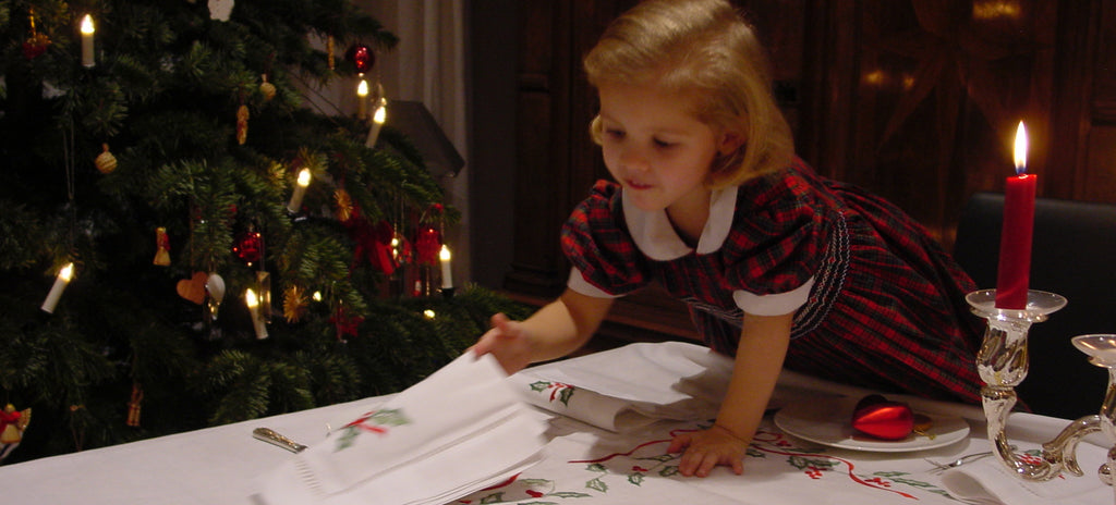 Napkins for Christmas, embroidered with Ilex. Illustration with child, Christmas tree and set table.