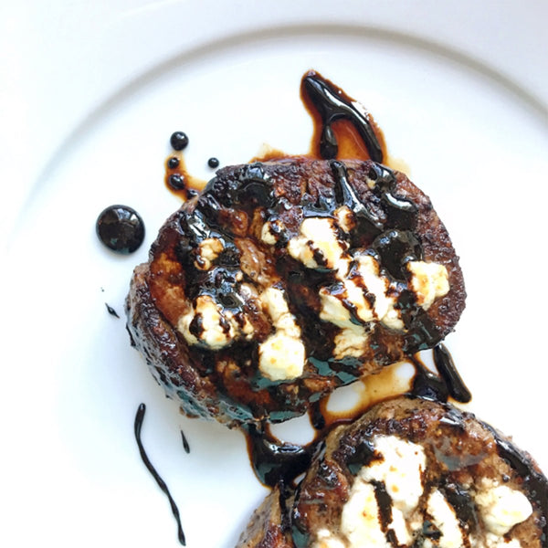 Two filet steaks on a plate with drizzle