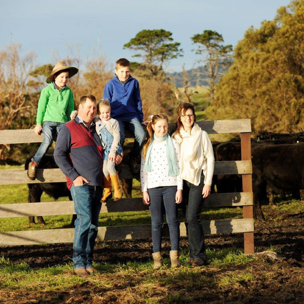 A family standing in front of their cattle.