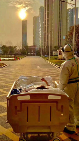 Wuhan Doctor stops to look at the sunset on their way to accompany patients for CT scan