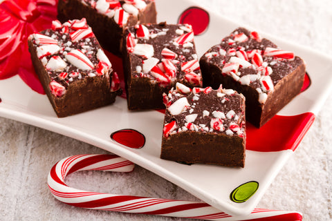 Brownies with candy canes on a white plate. A festive treat with rich chocolate and peppermint flavors.