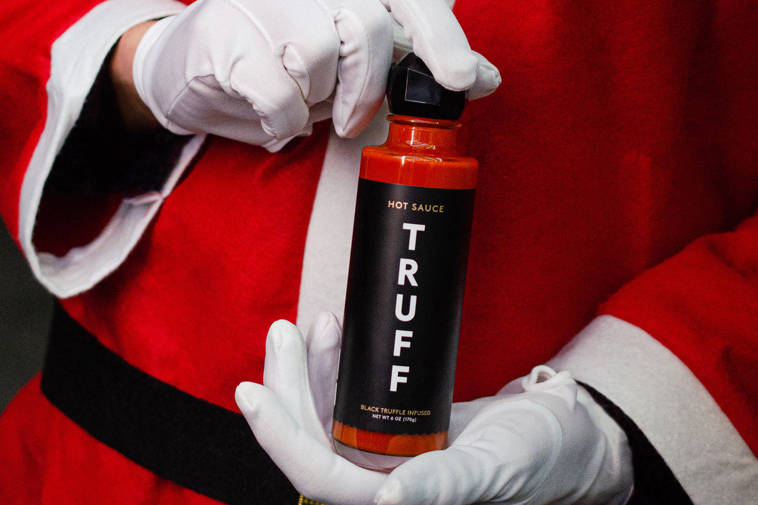 TRUFF Hot Sauce bottle held by Santa Claus