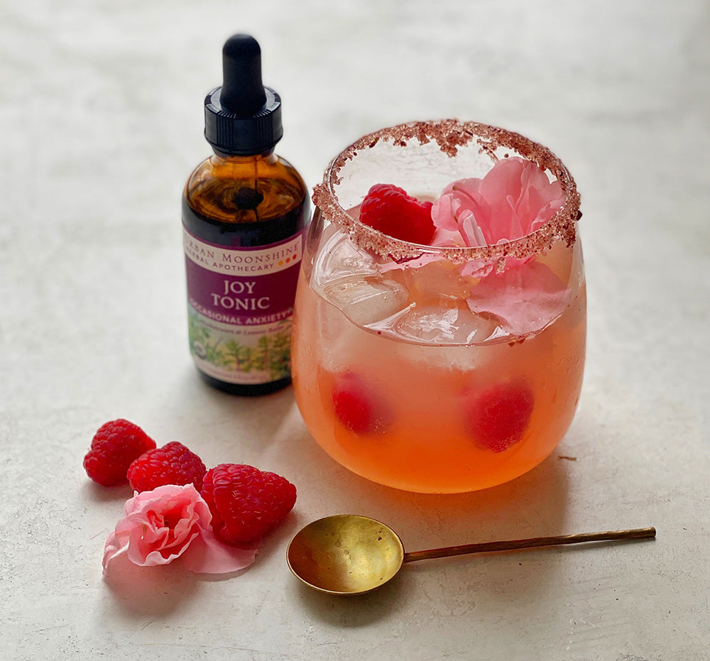 Kombucha Joy Tonic Sparklers with bottle of joy tonic, spoon and raspberries