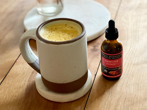 Golden milk in white mug with Immune Tonic