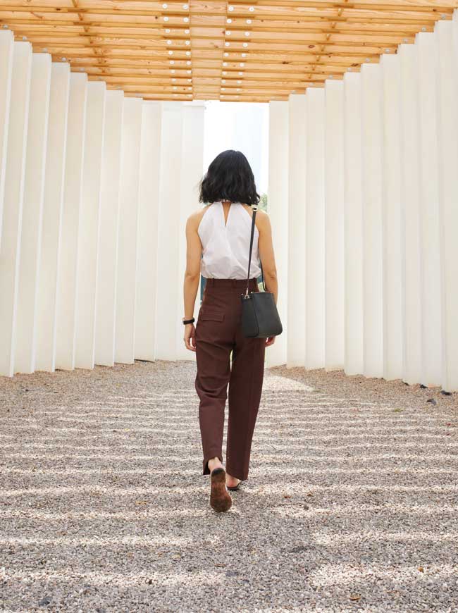 woman wearing Pearl walking away