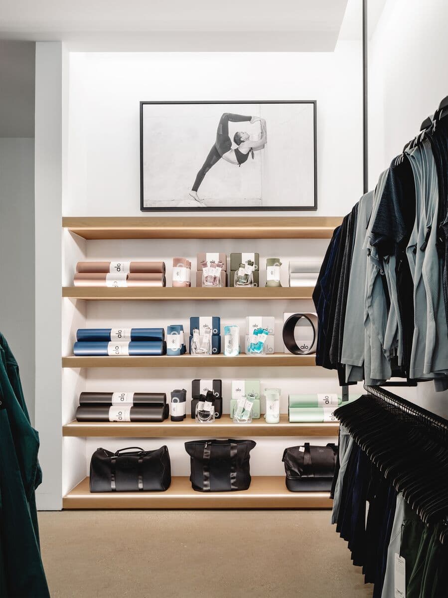 An photo of a shelving display with yoga mats and yoga gear within an Alo Yoga store.