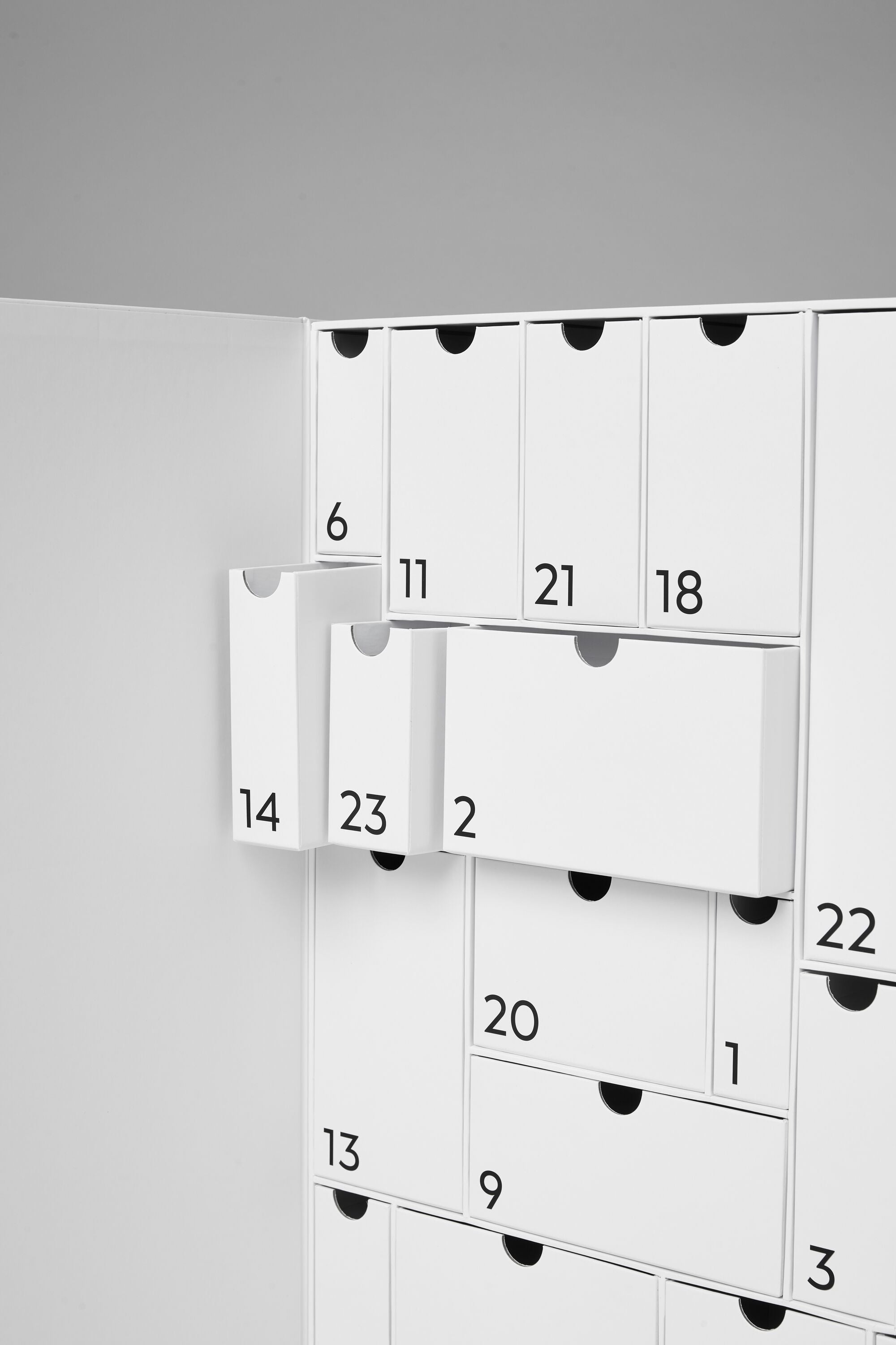 Shot of open advent calendar box showing the numbered drawers of all different sizes. 