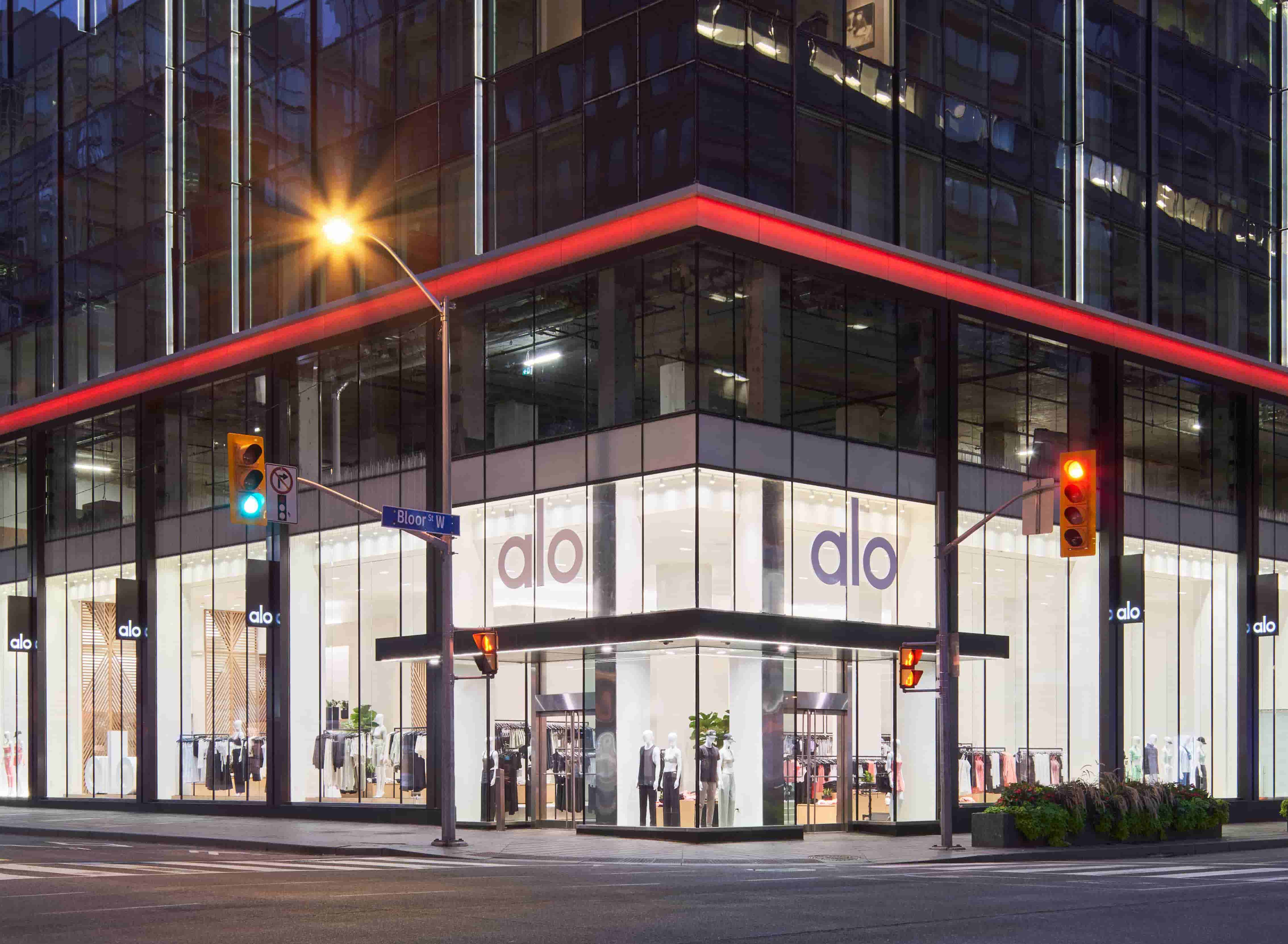 A photo of the Alo Yoga Storefront in Toronto showcasing the large floor-to-ceiling windows of this corner intersection store.  