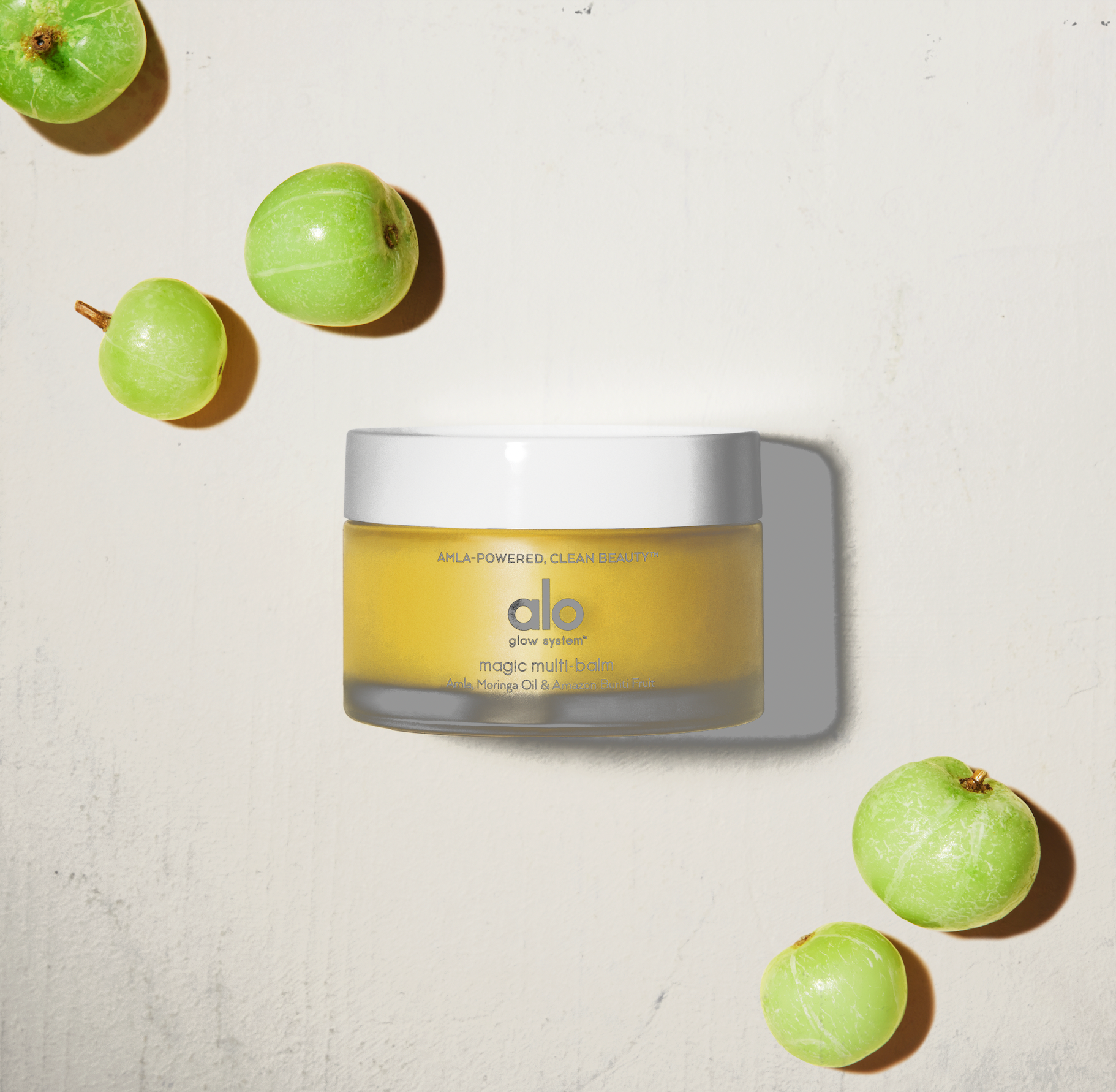 Flat lay of Magic Multi-Balm and green amla berries. 