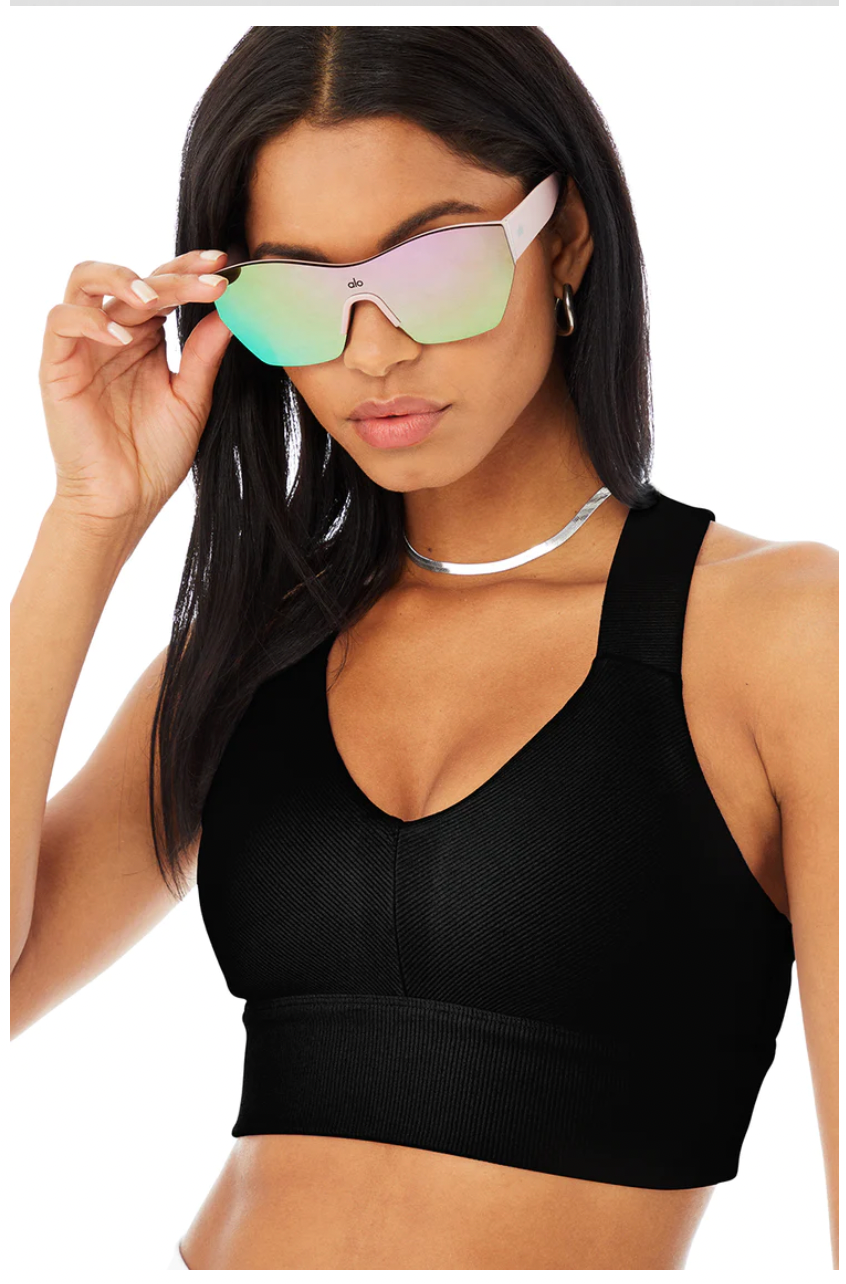 Model wearing Stunner Sunglasses posing in Black Sports Bra. 