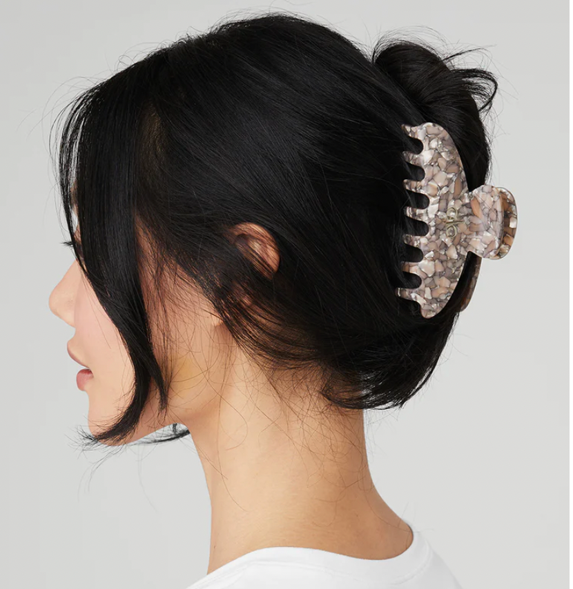 Side profile of dark-haired woman with hair in a French twist held with 90s Claw Clip. 