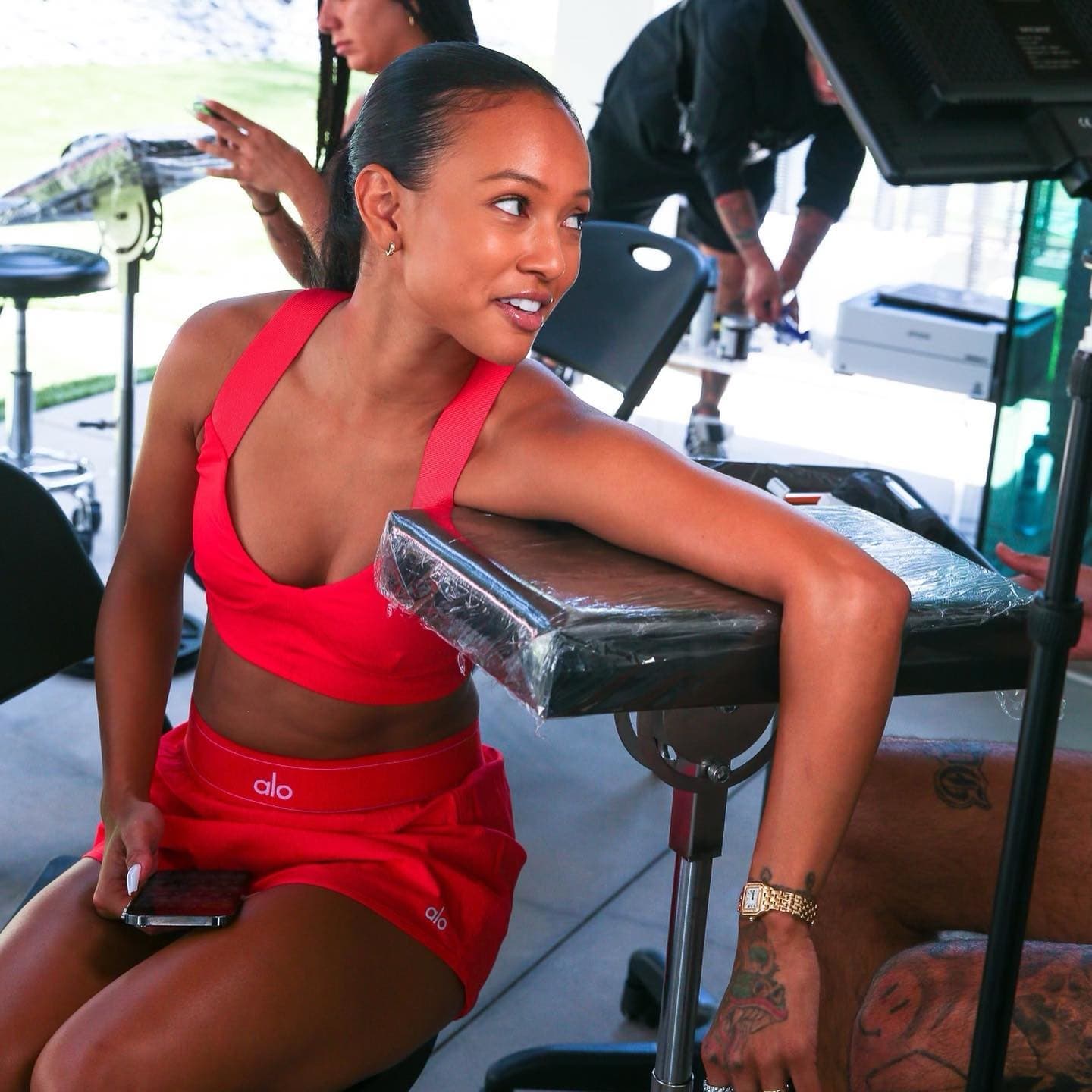 Karrueche Tran wearing a red a-line tennis skirt with a bustier-style seamed bra while getting a tattoo on her arm at Alo Summer House. 