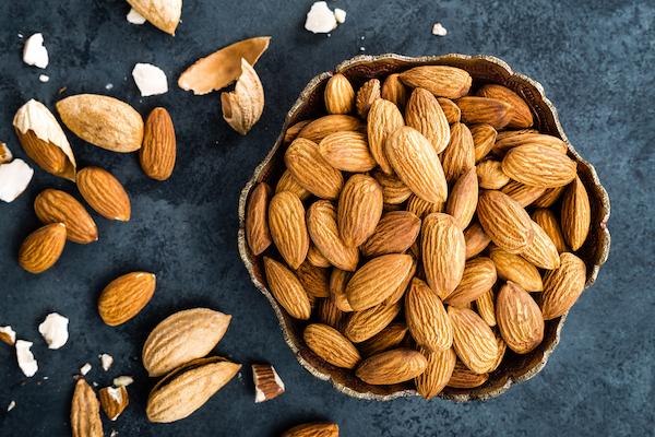Best nuts for weight loss Almonds on dark background