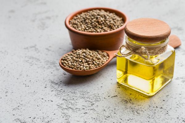 Bowl of hemp seeds and jar of hemp seed oil