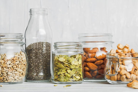 Nuts and Seeds in jars on a bench.